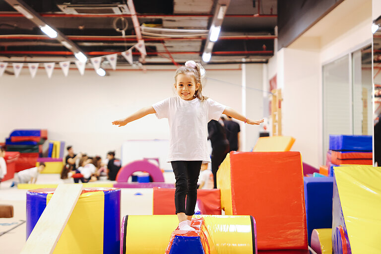 Mädchen macht Gymnastik in einer Turnhalle. 