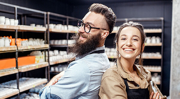 Mann und Frau Rücken an Rücken lachend