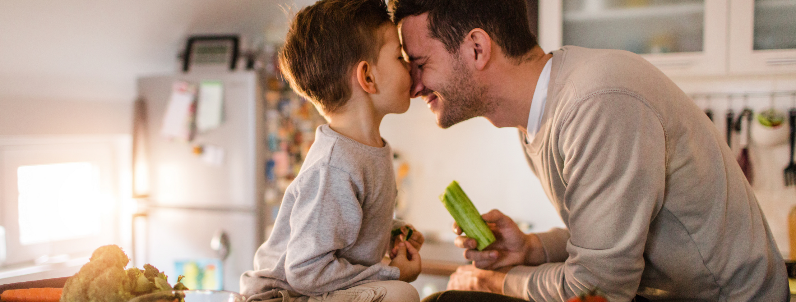 Vater mit Sohn in der Küche beim Gemüse zubereiten.