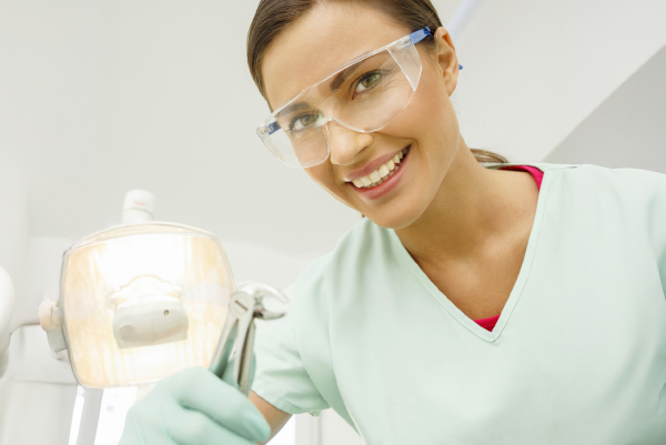 Eine Zahnärztin hält eine Zahnarztzange in die Kamera